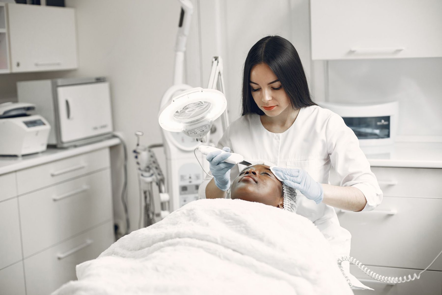 Esteticista evaluando la piel con lámpara de aumento
